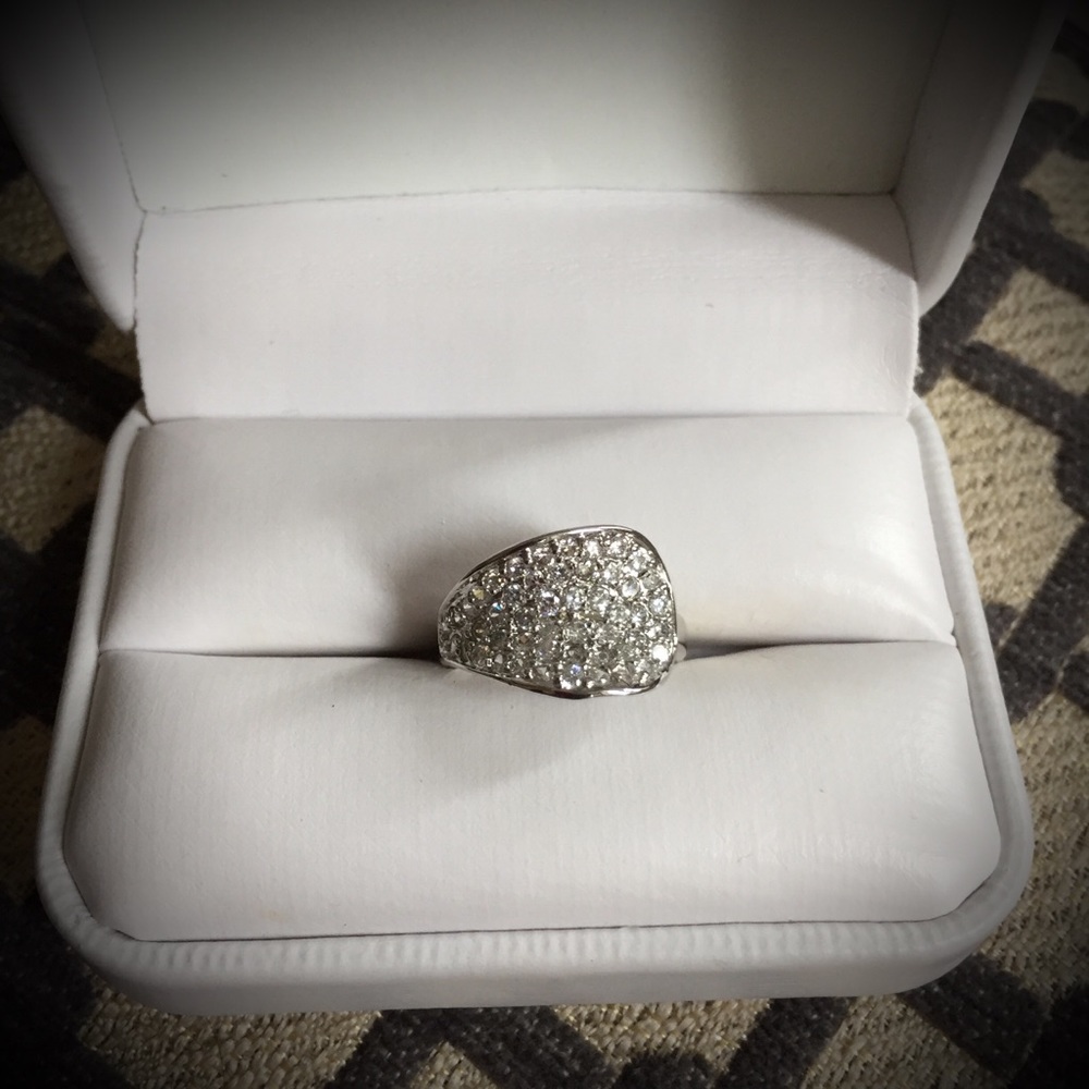 Pave stones in rhodium coated metal ring setting.